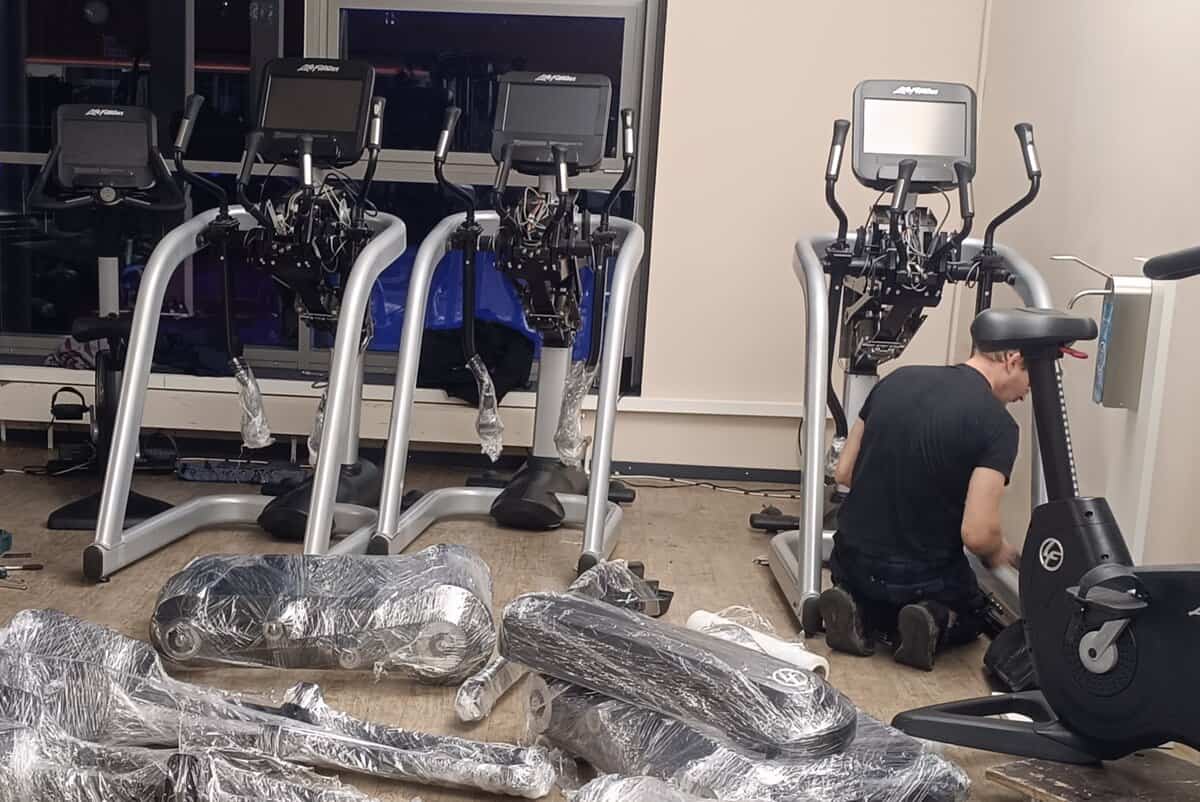 Fitnessgeräte Techniker baut auf und macht Installation von Trainingsgeräten