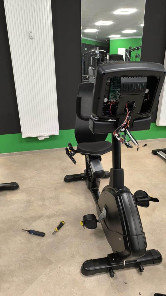 Techniker repariert und wartet Fitnessgerät in einem Fitnessstudio